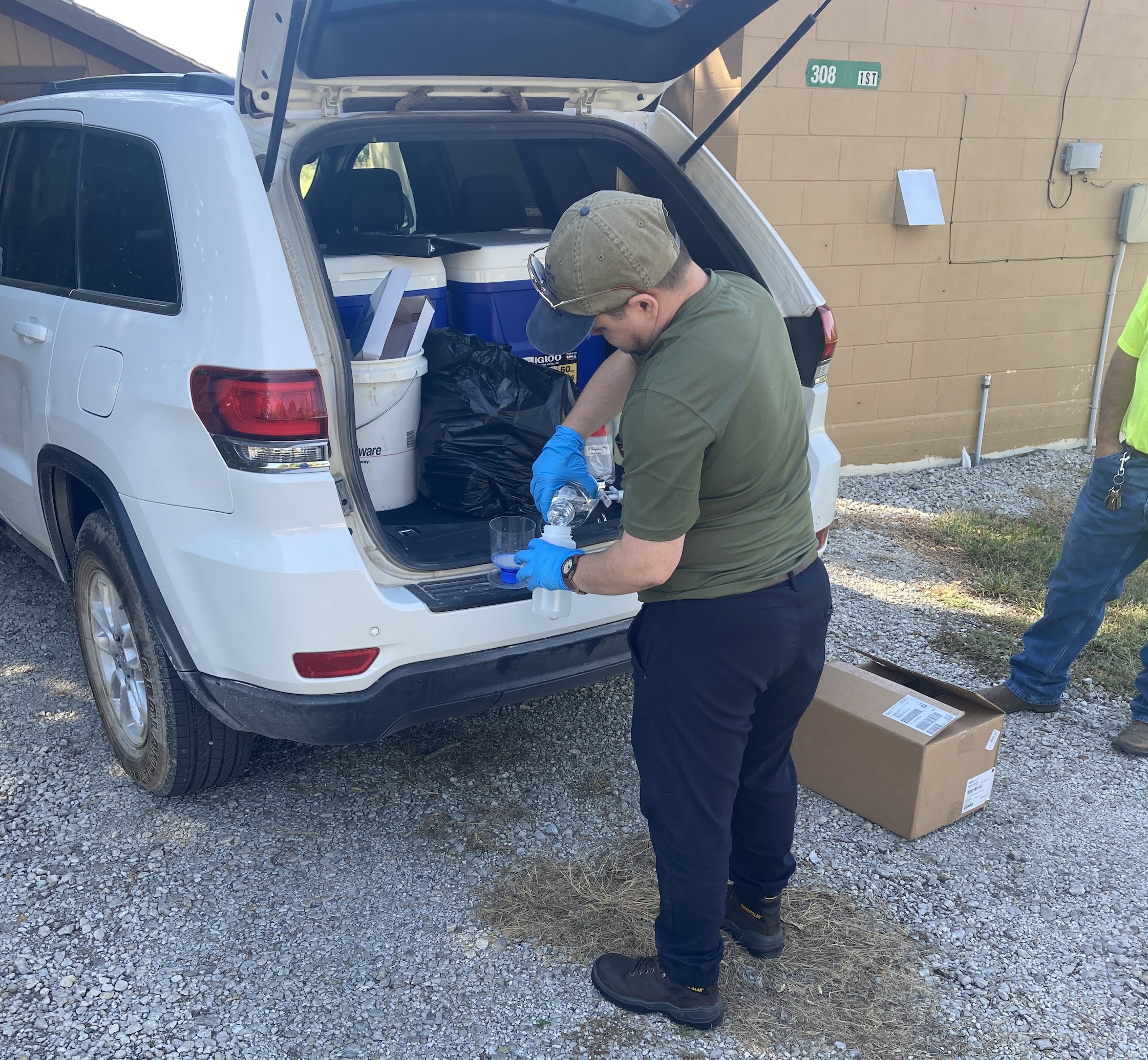 Staff member collects a water sample.