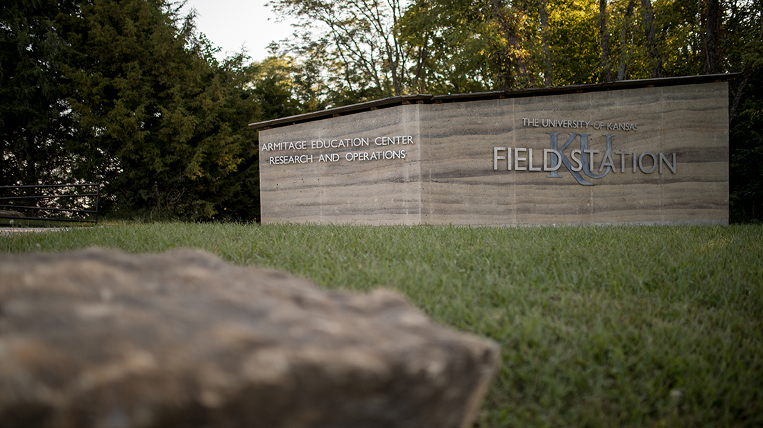 Earthen wall with text "University of Kansas Field Station"