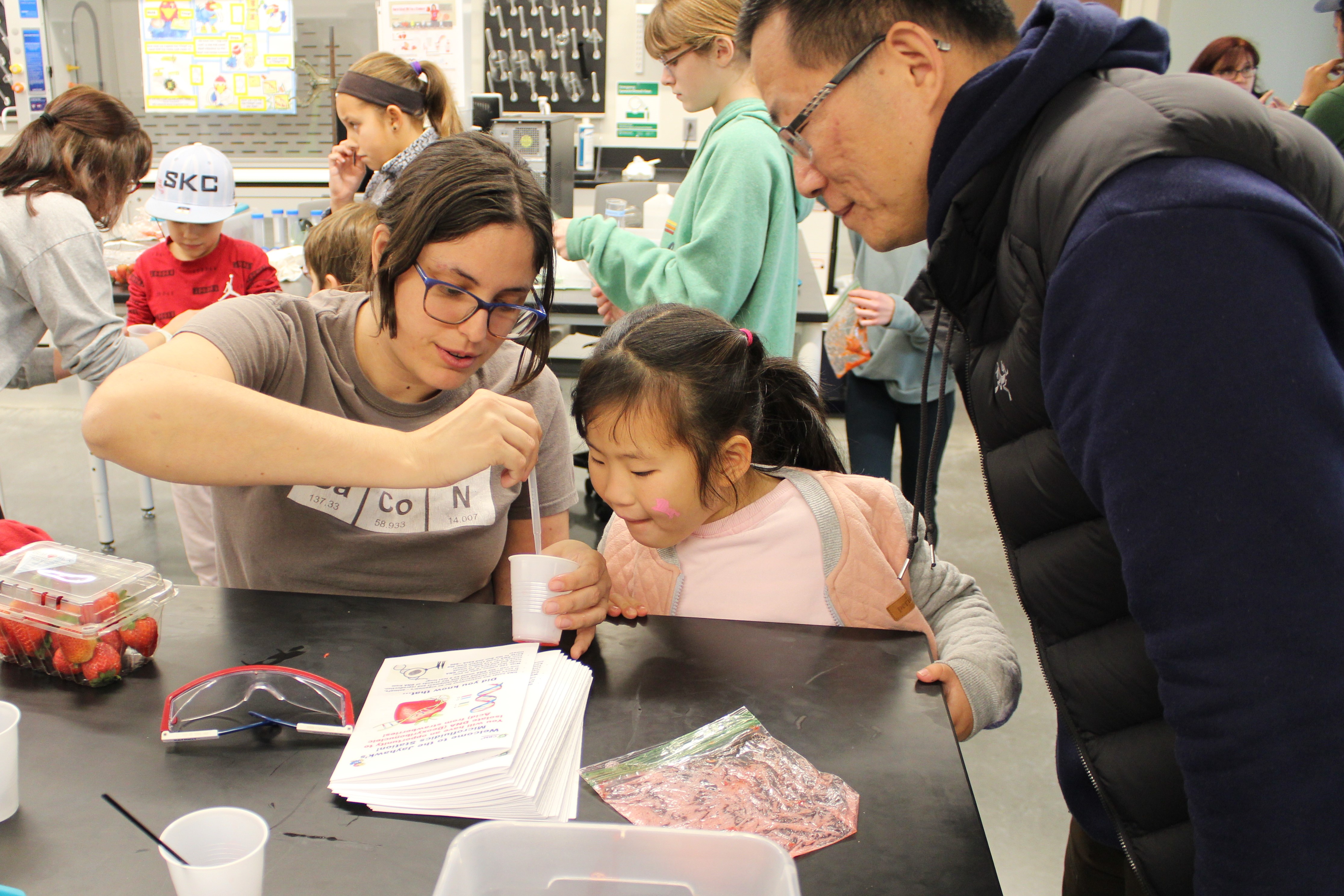 A dad and child receiving assistance from a helper.