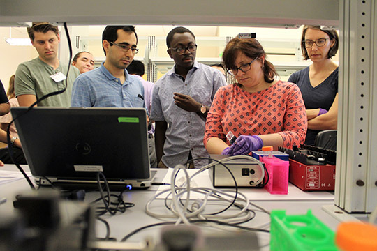 Maggie connects the chip to the Coulter Counter electroincs and fluorescence microscope.