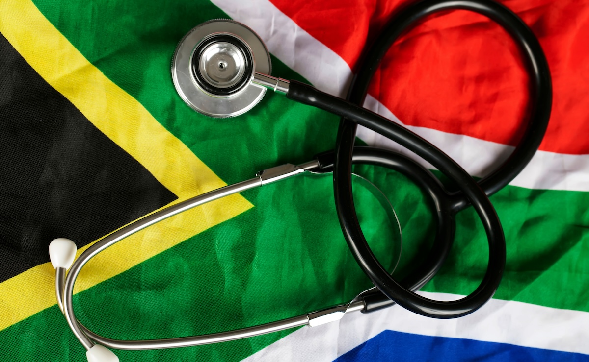 A stethoscope lays on top of a South African flag.
