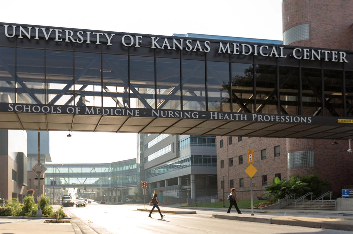 KU Medical Center walkway in Kansas City, with two individuals walking underneath.