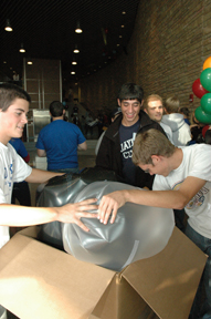 A team crams their dirigible into the size-testing box