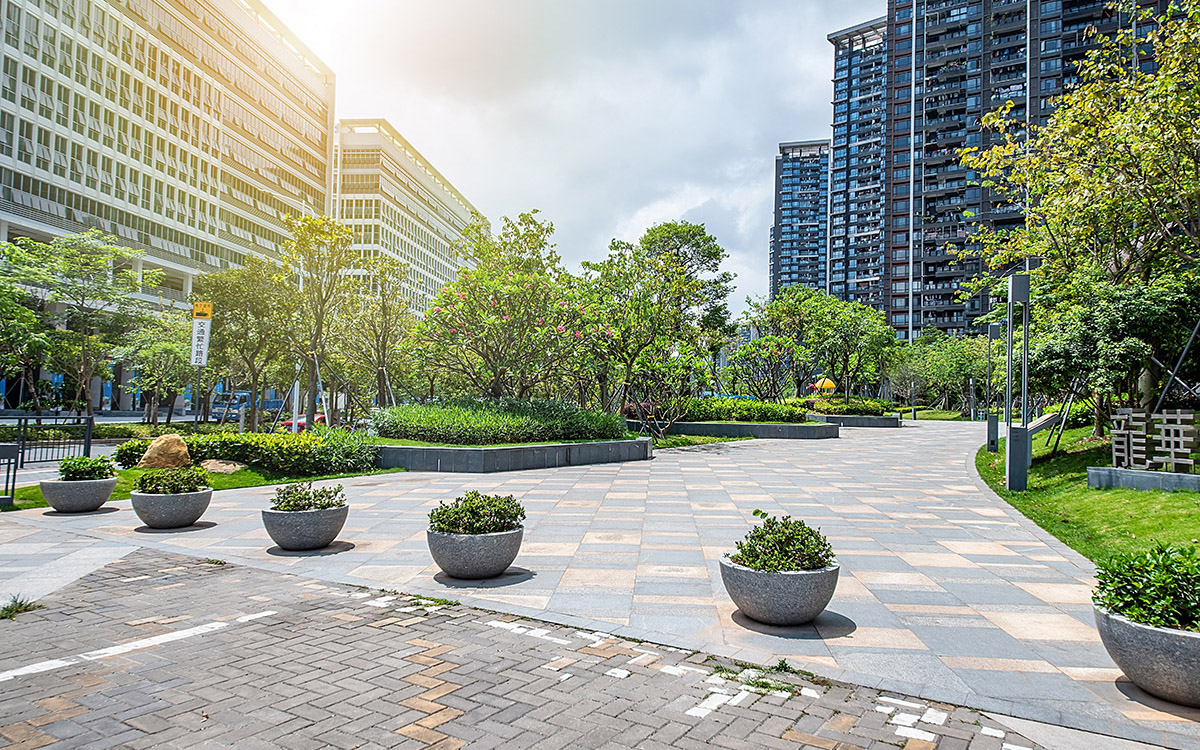 An image of a city space with trees and greenery interspersed with high rise buildings.