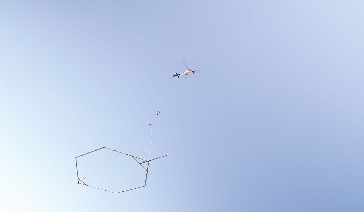 Airborne electromagnetic surveying include plane with hanging frame in blue sky