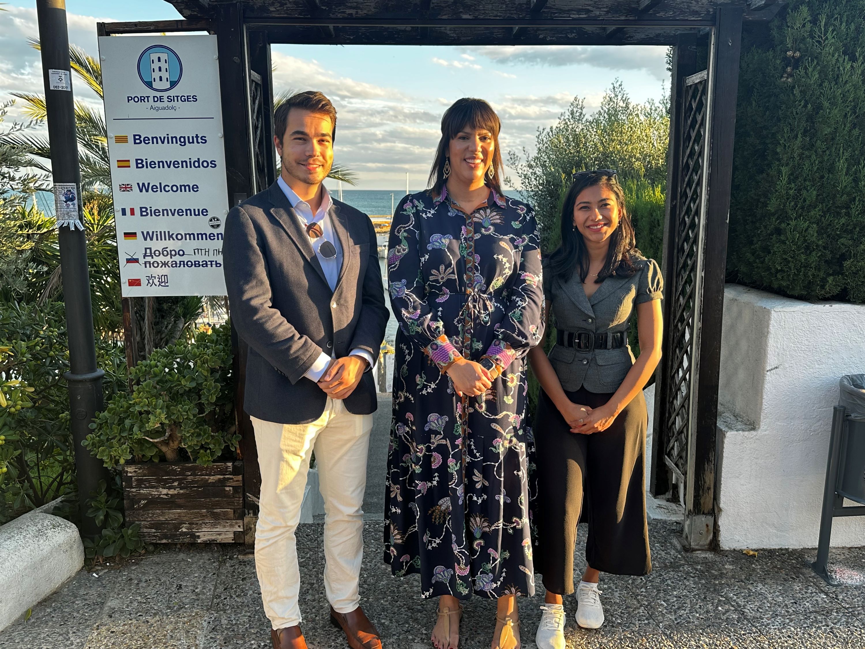 CARE researchers Dr. Kelsie Forbush, Robert William Morgan IV, and Sonakshi Negi pose in front of the Mediterranean Sea smiling.