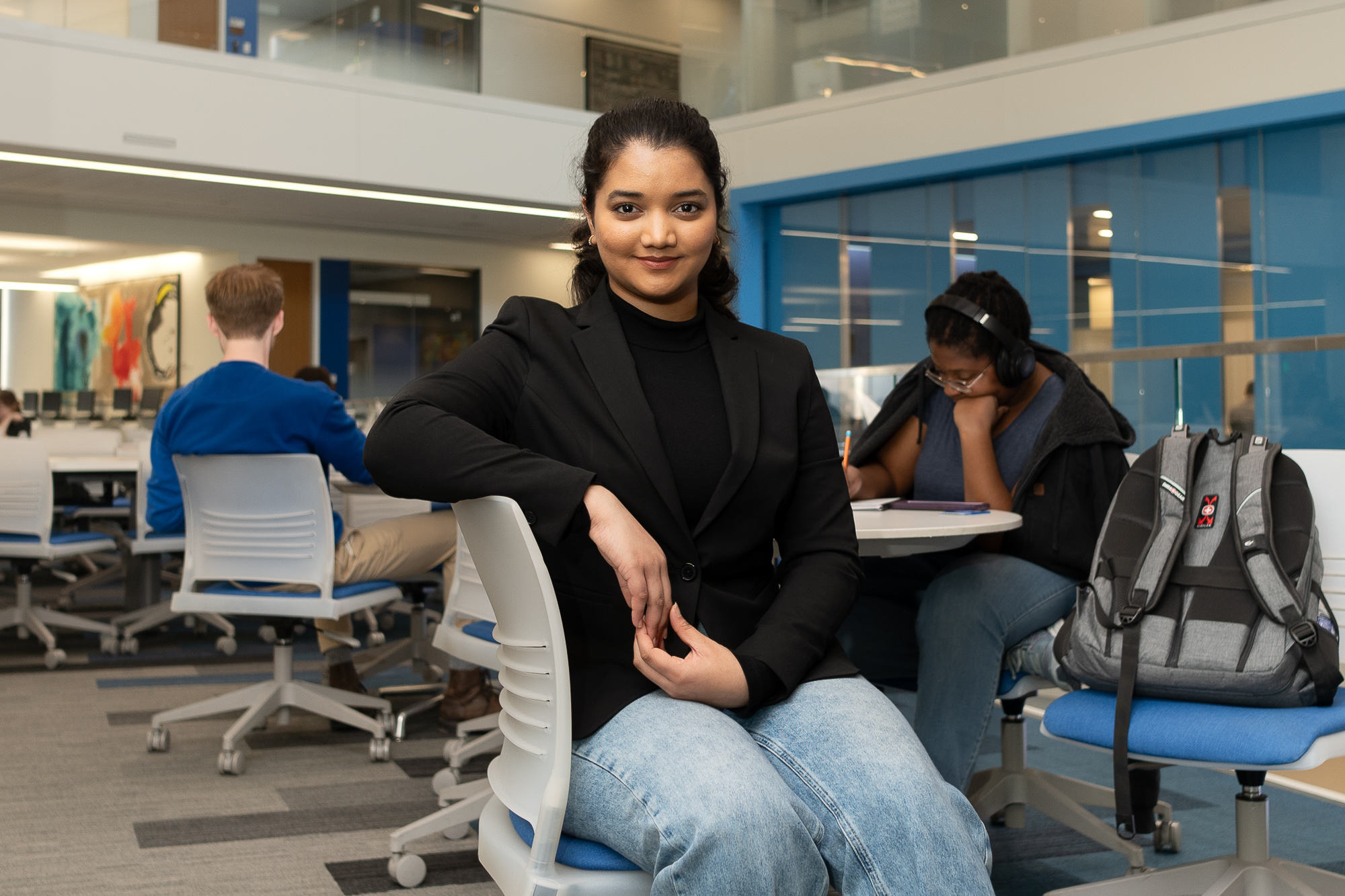 Nomina Thara Koneti in a study area of KU's Capitol Federal Hall, with other students in the background