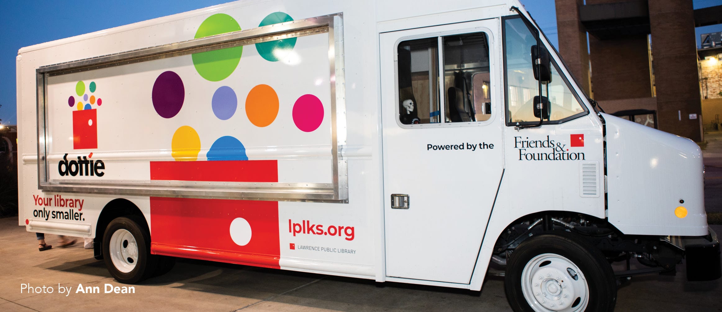 Color photograph of a white with multicolored polka dots bookmobile truck. Photograph by Ann Dean