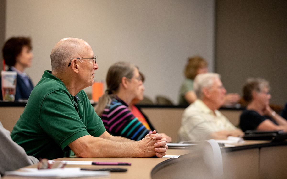 Individuals sit in lecture hall for Osher Institute event at the KU Edwards Campus.
