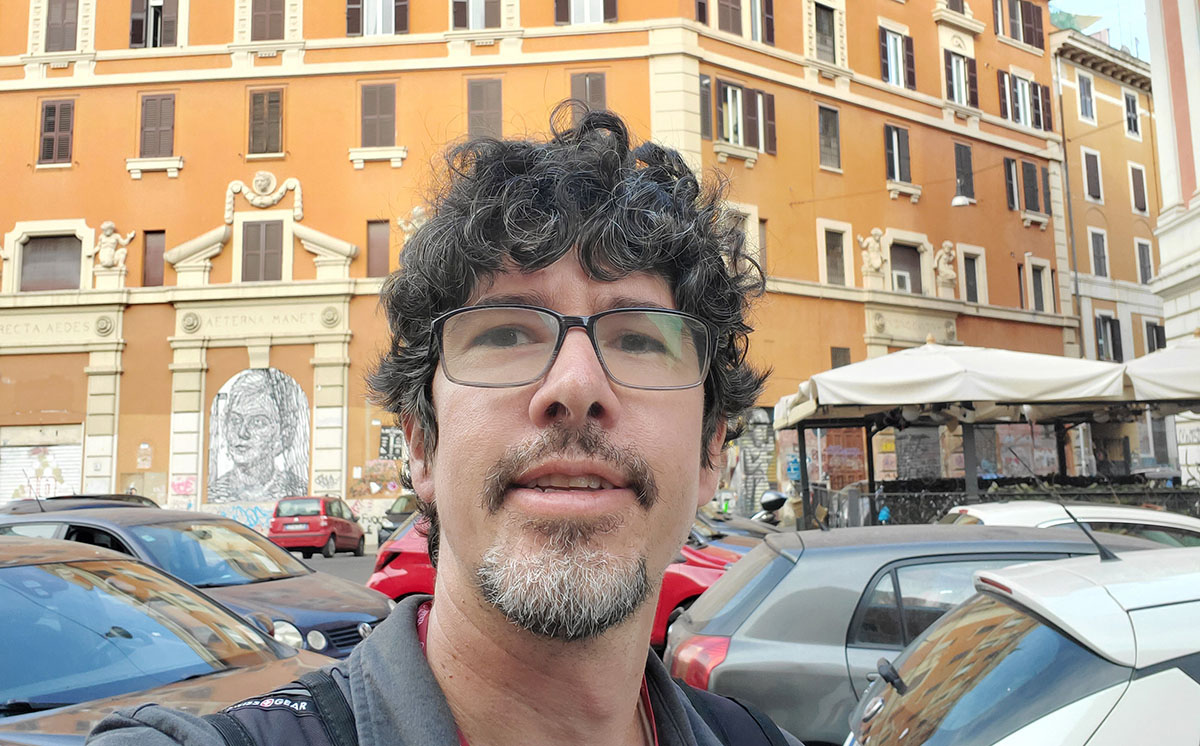 Edward Bowen standing in front of a large building in Rome, once used as the Cinema Palazzo.