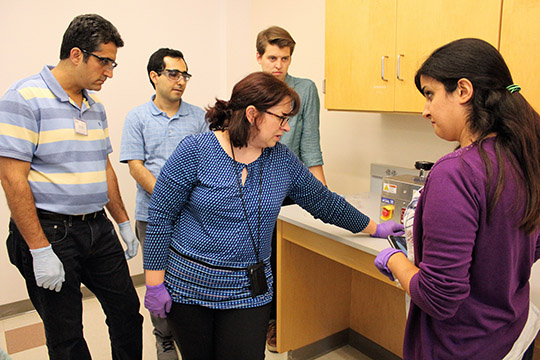 Maggie shows a few people how to UV/Ozone treat their chip and coverplate before assembly.