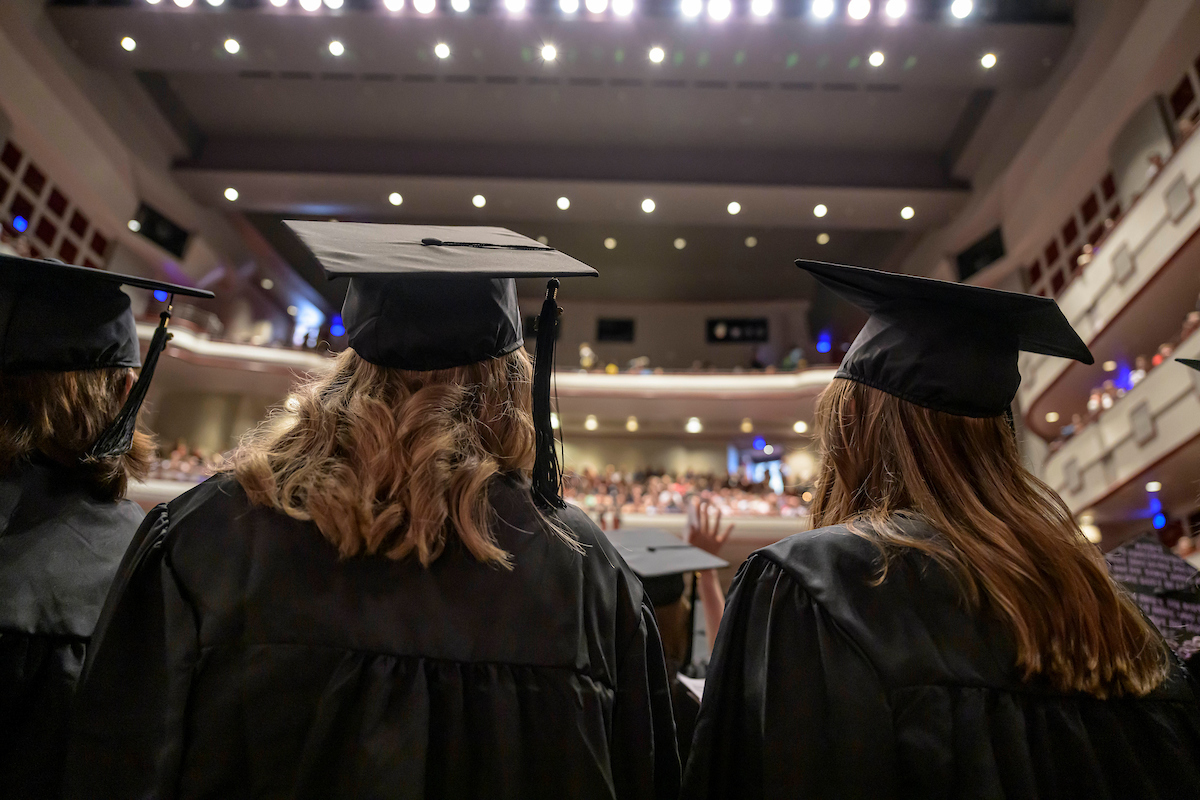 Social Welfare students look into the crowd at Lied Center during graduation day.