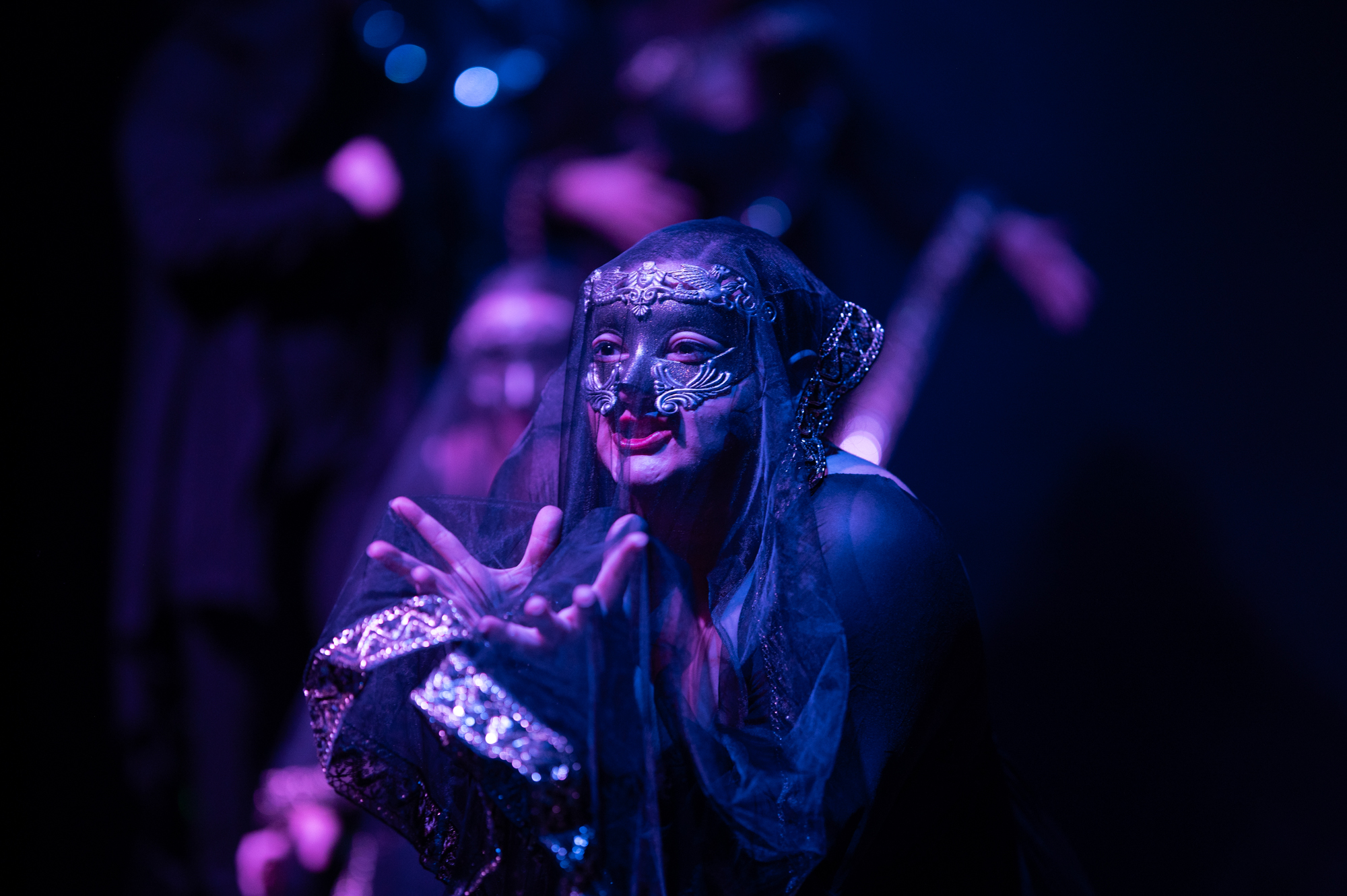 A masked performer appears onstage.
