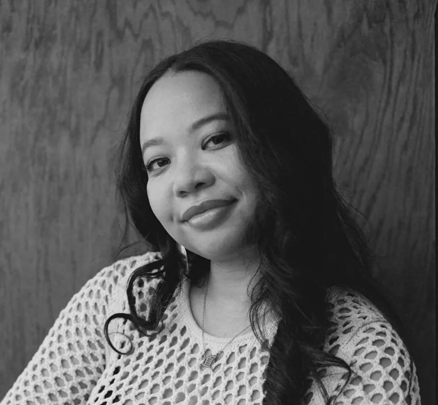 Black and white photo of a woman looking at the camera, smiling