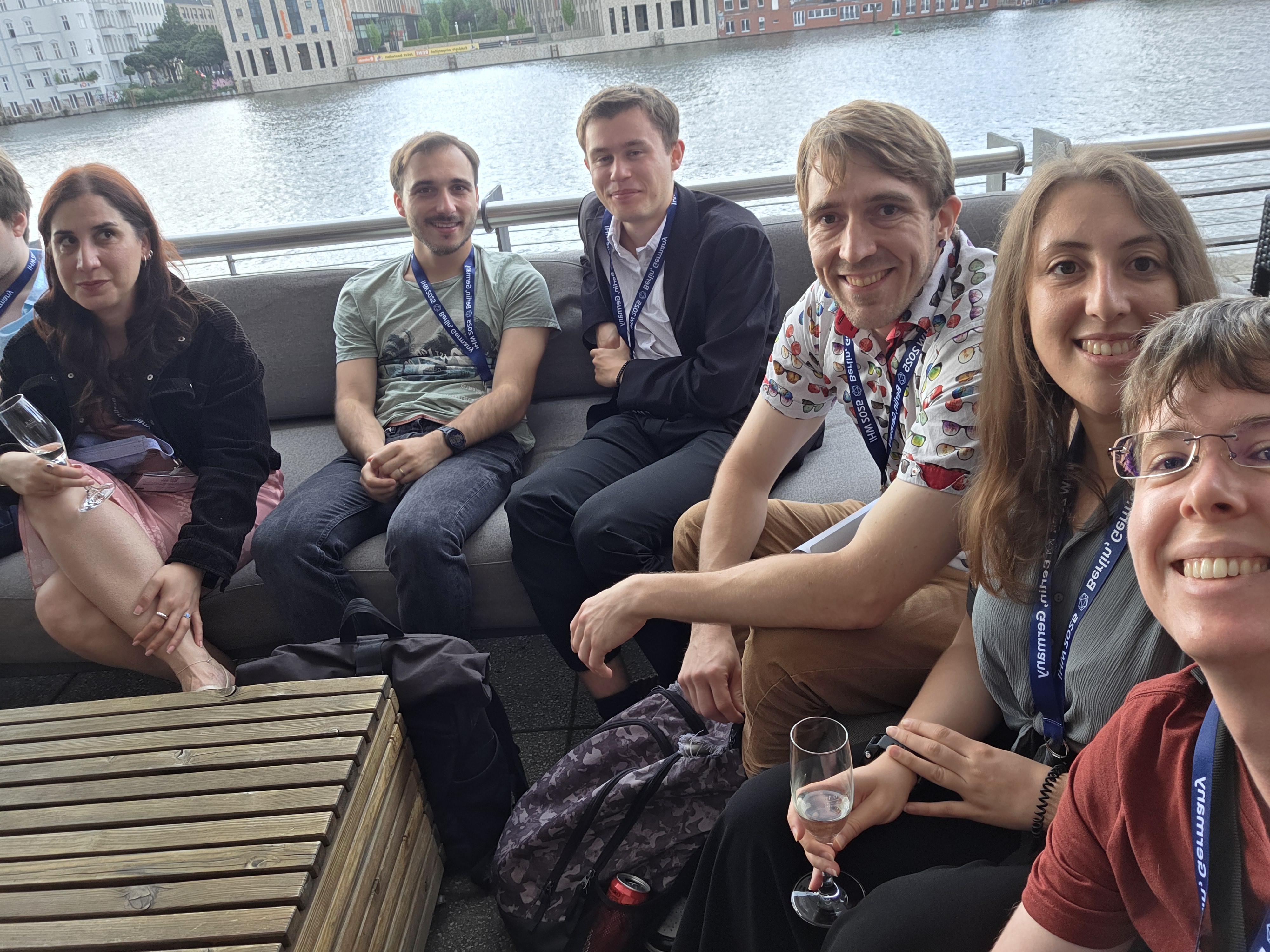 Erick McCloskey along with other conference atendees sit outside on a deck overlooking a river in Hannover.
