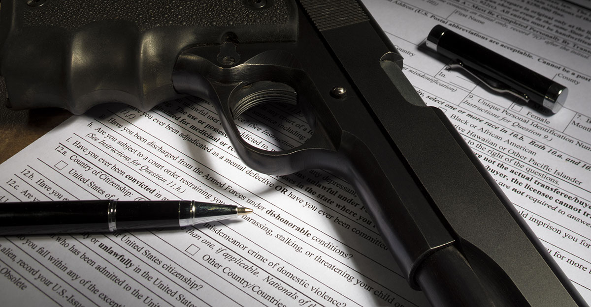 Handgun atop paper gun permit.