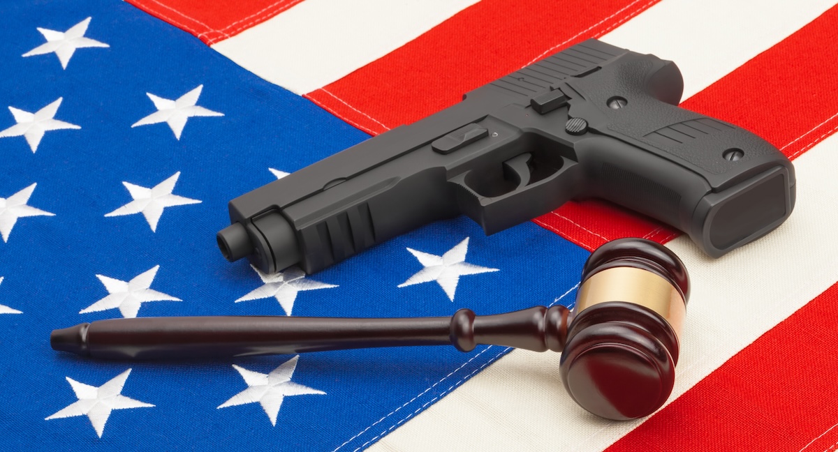 A photo shows a pistol and gavel placed on top of an American flag.