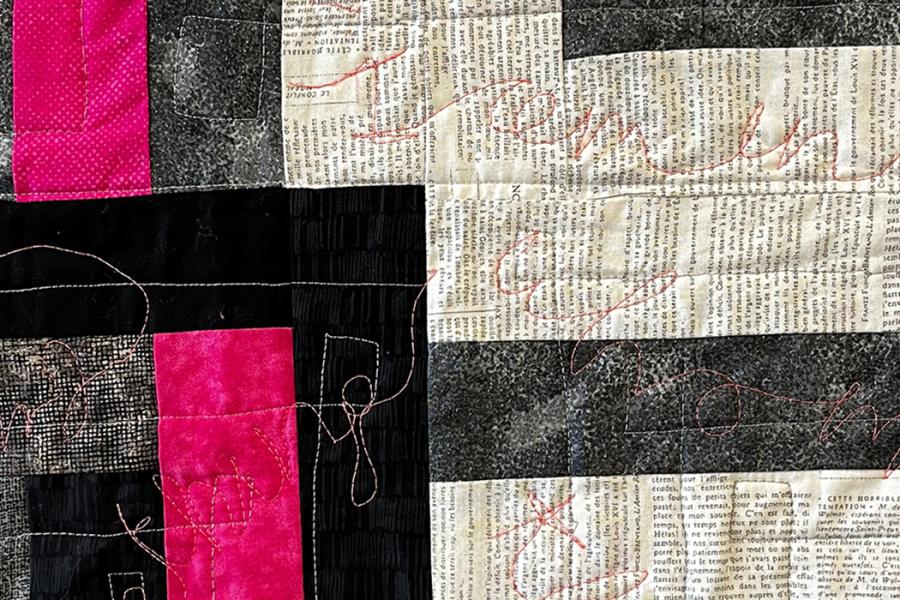 Quilt blocks of fuschia, grey, black with gold embroidered text