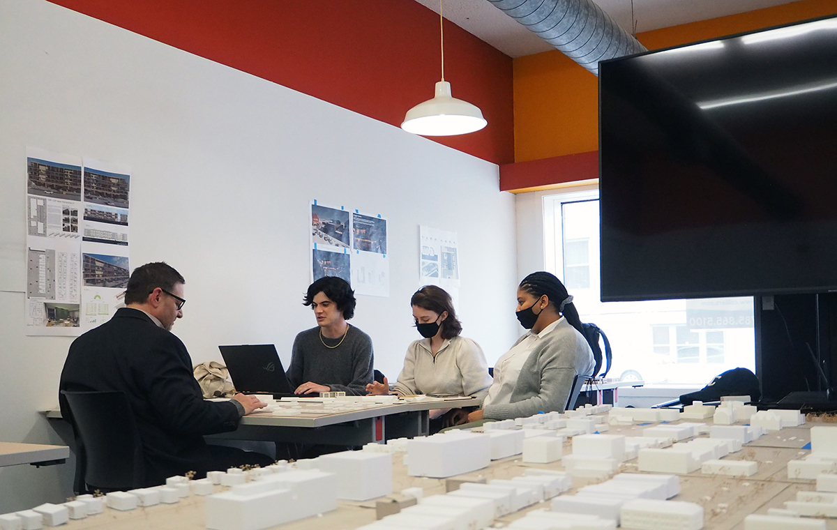 Professor Joe Colistra (at far left) discusses HUD competition project with architecture students (left to right) John Hardie, Elizabeth Overschmidt, and Samara Lennox.