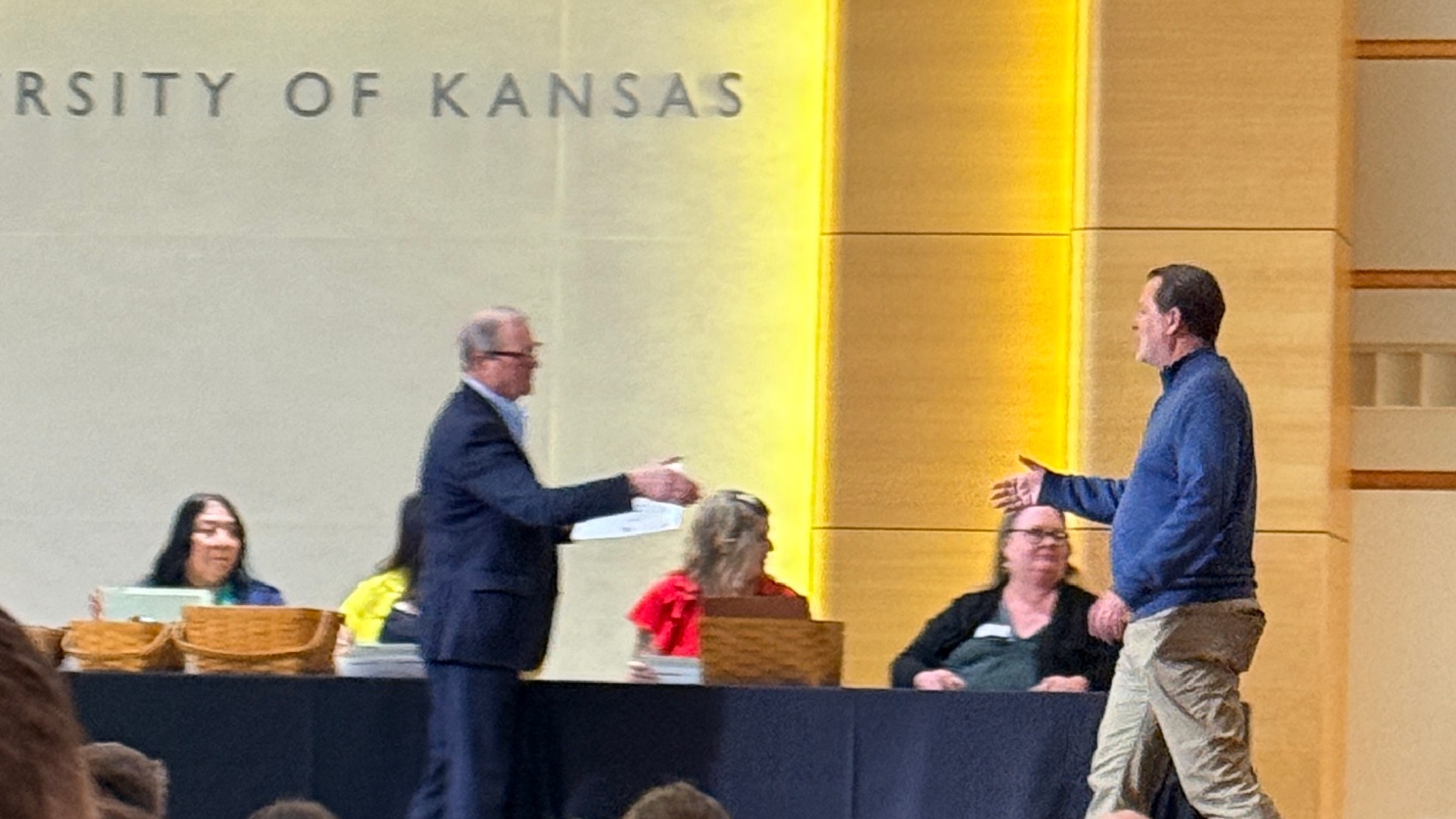 Dr. Scott Hefty walks across stage to shake hands with Chancellor Girod.