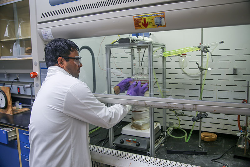 Sandip Singh, associate researcher at KU’s Center for Environmentally Beneficial Catalysis, prepares equipment used to chemically recycle corn cob waste from Kansas farm fields into ingredients for everyday products.