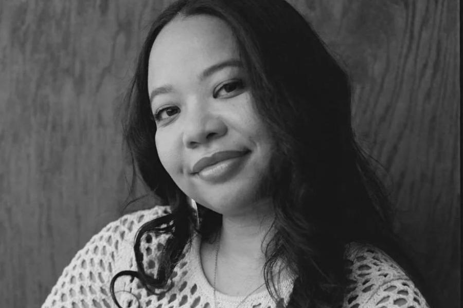 Black and white photo of a woman looking at the camera, smiling