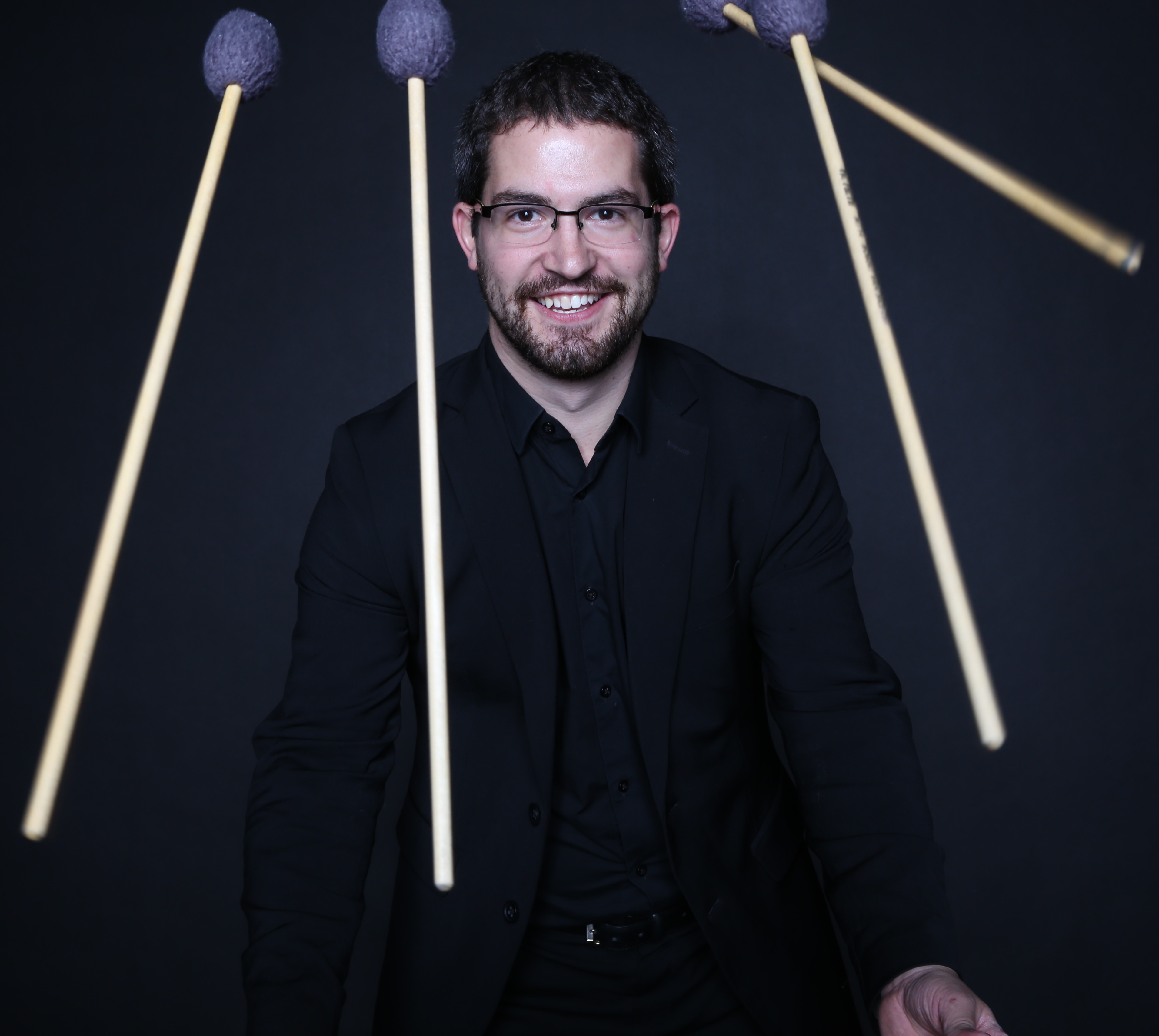 a man posing with mallets in front of him