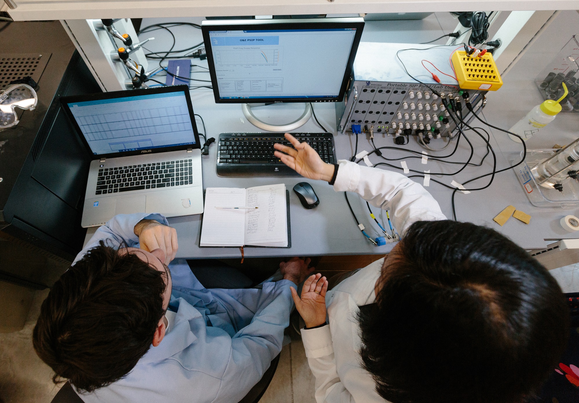 Two researchers collaborating in front of a lab computer