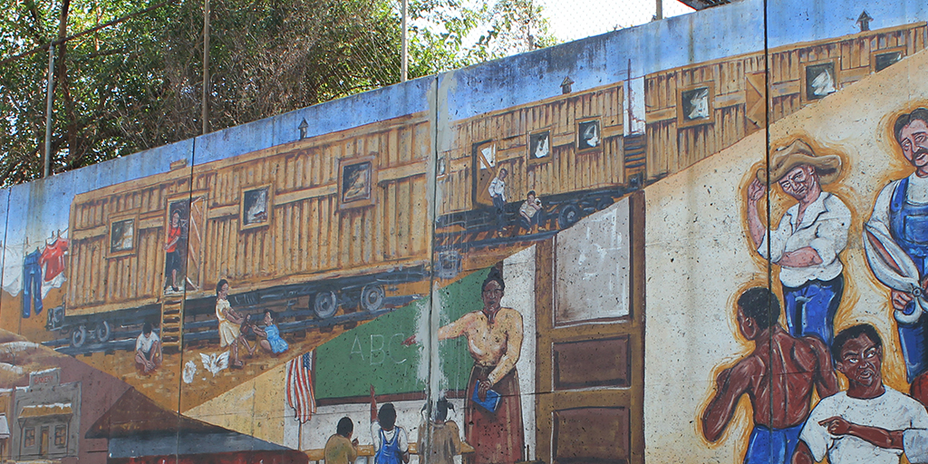 Image: Migrants who lived in converted boxcars are depicted in a mural in the Argentine neighborhood of Kansas City, Kansas. Credit: Rick Hellman, KU News Service.