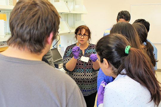 Maggie teaches the group about painting silver/silver chloride electrodes onto their chips using a syringe.