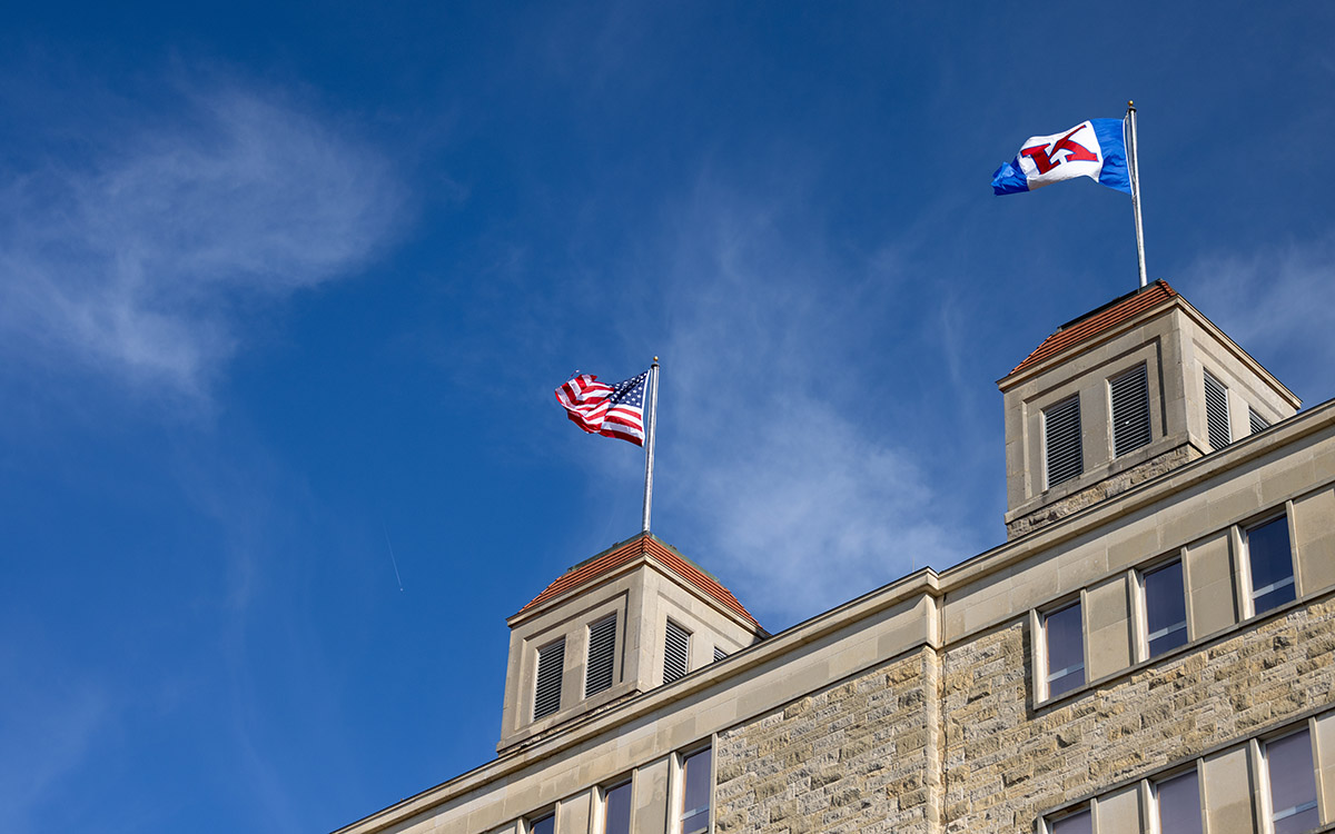 American, KU flags atop Fraser Hall.