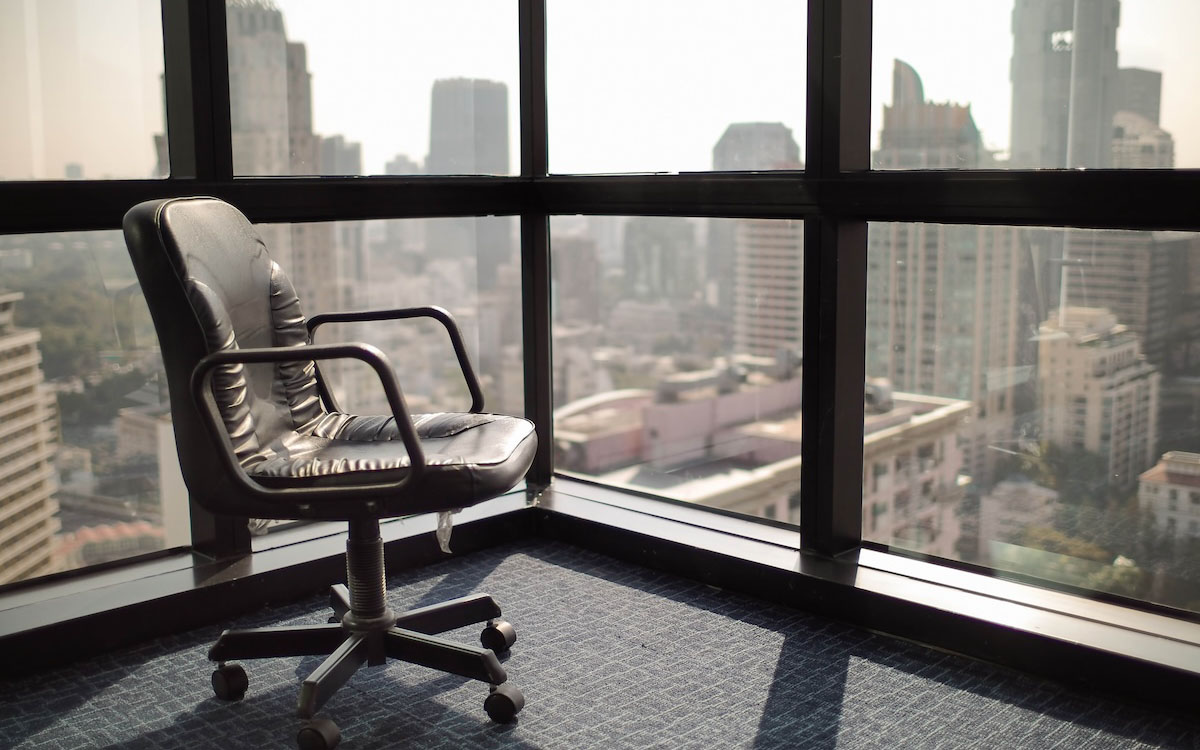 An empty chair sits overlooking the view from a corporate office.
