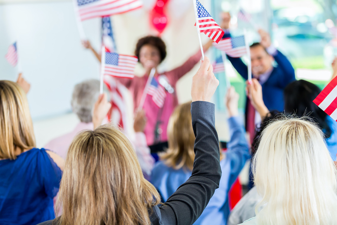 Photo of people raising small American flags
