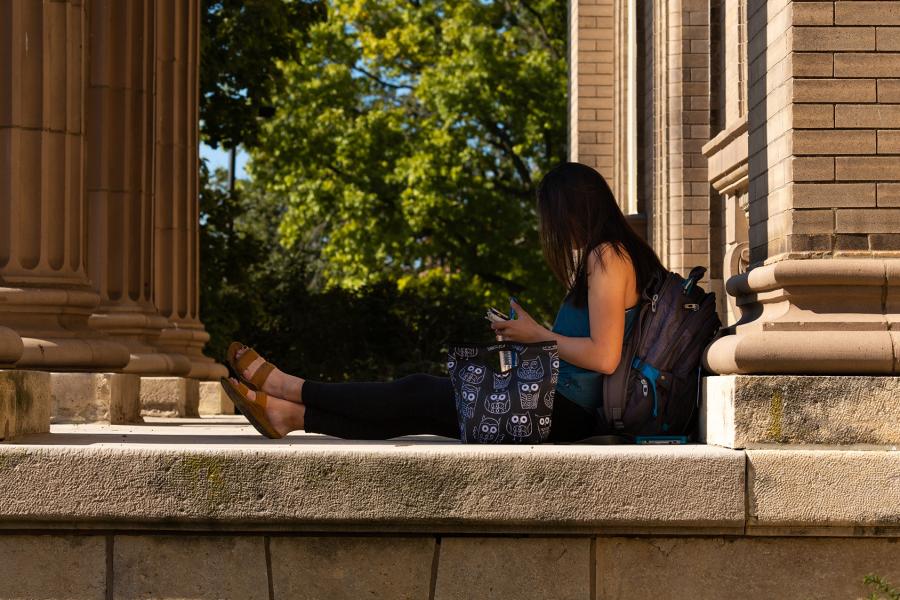 Student in front of Lippincott Hall, home of KU's Applied English Center.