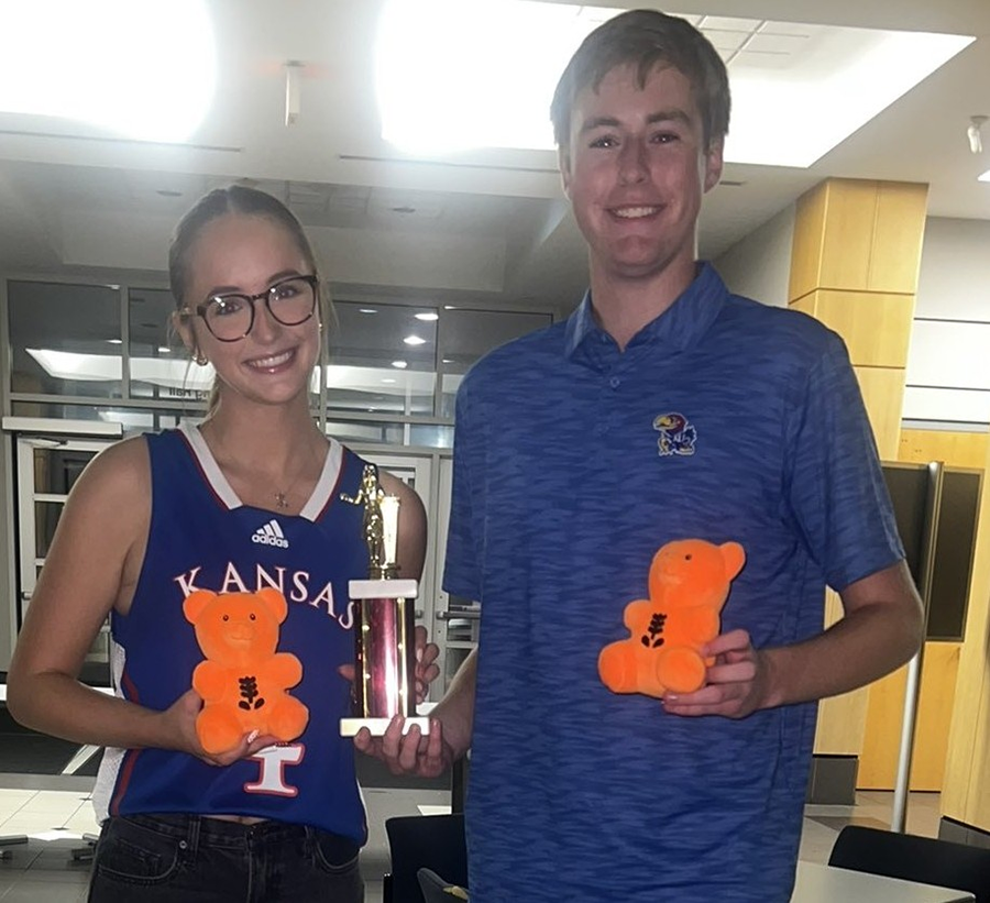 KU Debaters Lucy Pace and Chase Blaser holding a trophy and Missouri State University bears.