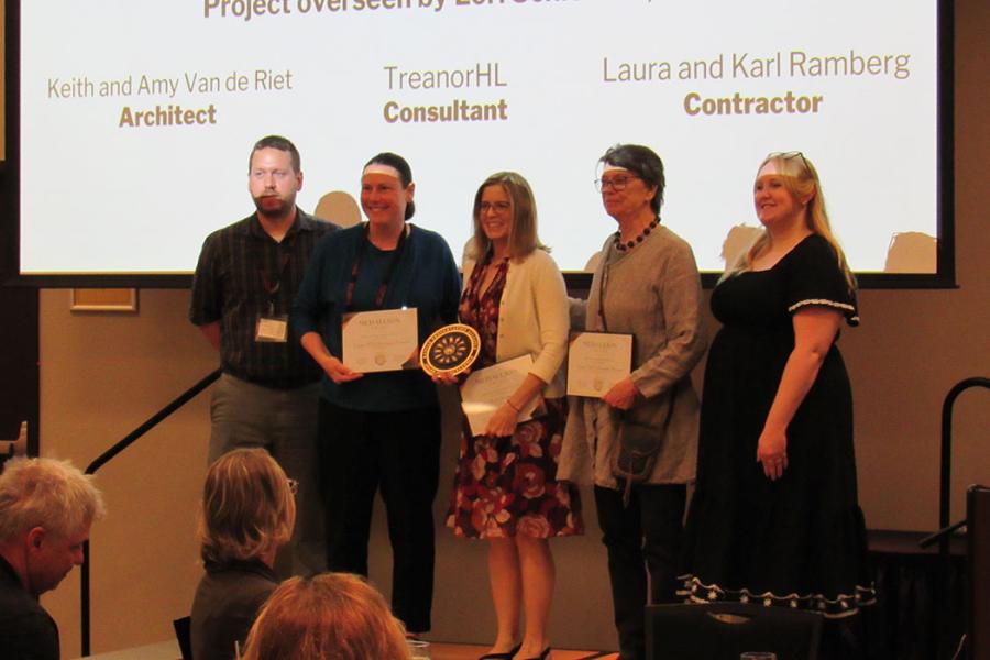 Team members accept award on stage for the Grotesque Renewal Project