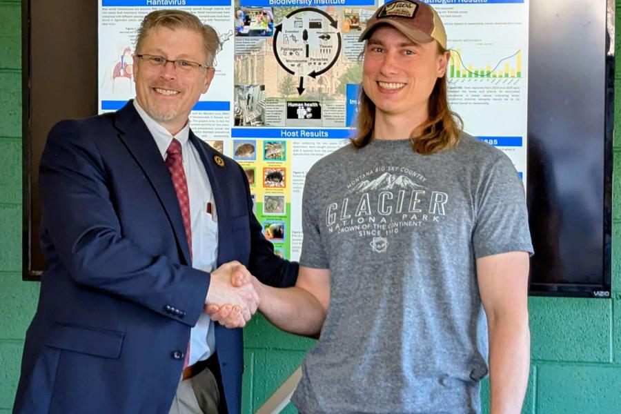 Ric Steele Jr., Committee Chair, presents EBB PhD student Ben Wiens with KU’s Graduate Student Distinguished Service Award.
