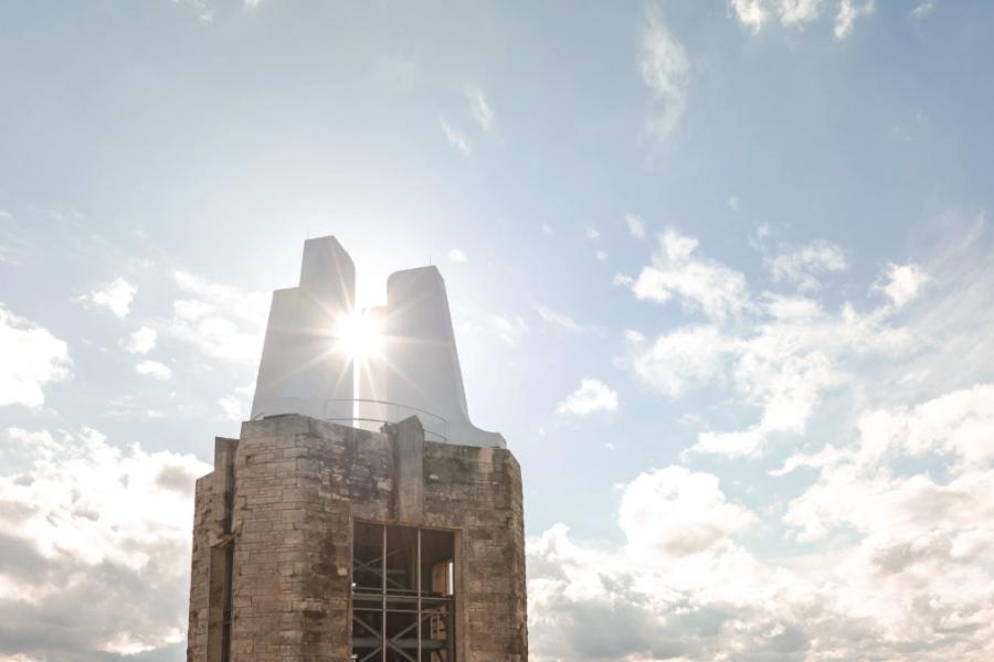 Sun peeks through clouds near Campanile at the University of Kansas.