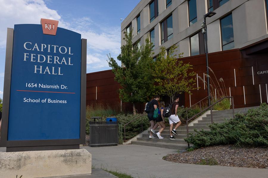 Students walk up the steps to Capitol Federal Hall, home to the University of Kansas School of Business.