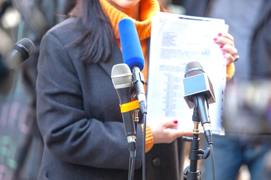 A spokesperson for a politician accused of corruption presents evidence to reporters at a press conference.