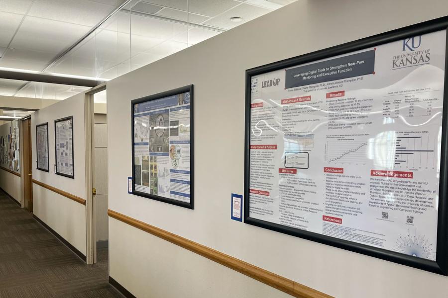 Four research posters on display on a wall in Anschutz Library.