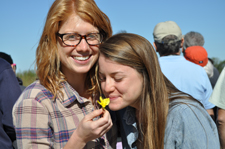 Two tour group members smelling a flower