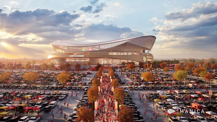 Architectural rendering of the proposed Kansas City Chiefs stadium designed by MANICA Architecture. The contemporary stadium features a sweeping curved roof and expansive glass facades. A wide pedestrian promenade leads to the main entrance, lined with trees and event banners, while parking areas filled with vehicles surround the stadium. The scene is illuminated by warm evening light beneath a dramatic sky with scattered clouds.