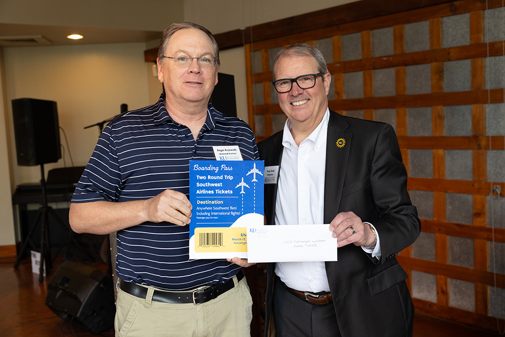 Roger Rajewski, research professor of pharmaceutical chemistry, won the grand prize of two round-trip tickets to anywhere Southwest Airlines flies. He is pictured with Chancellor Douglas A. Girod.