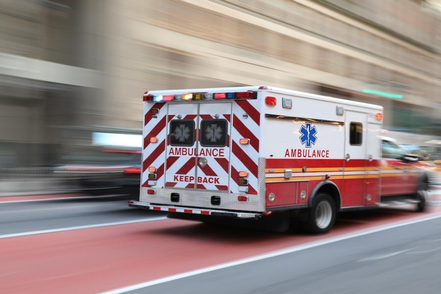 An ambulance speeds through a city street.