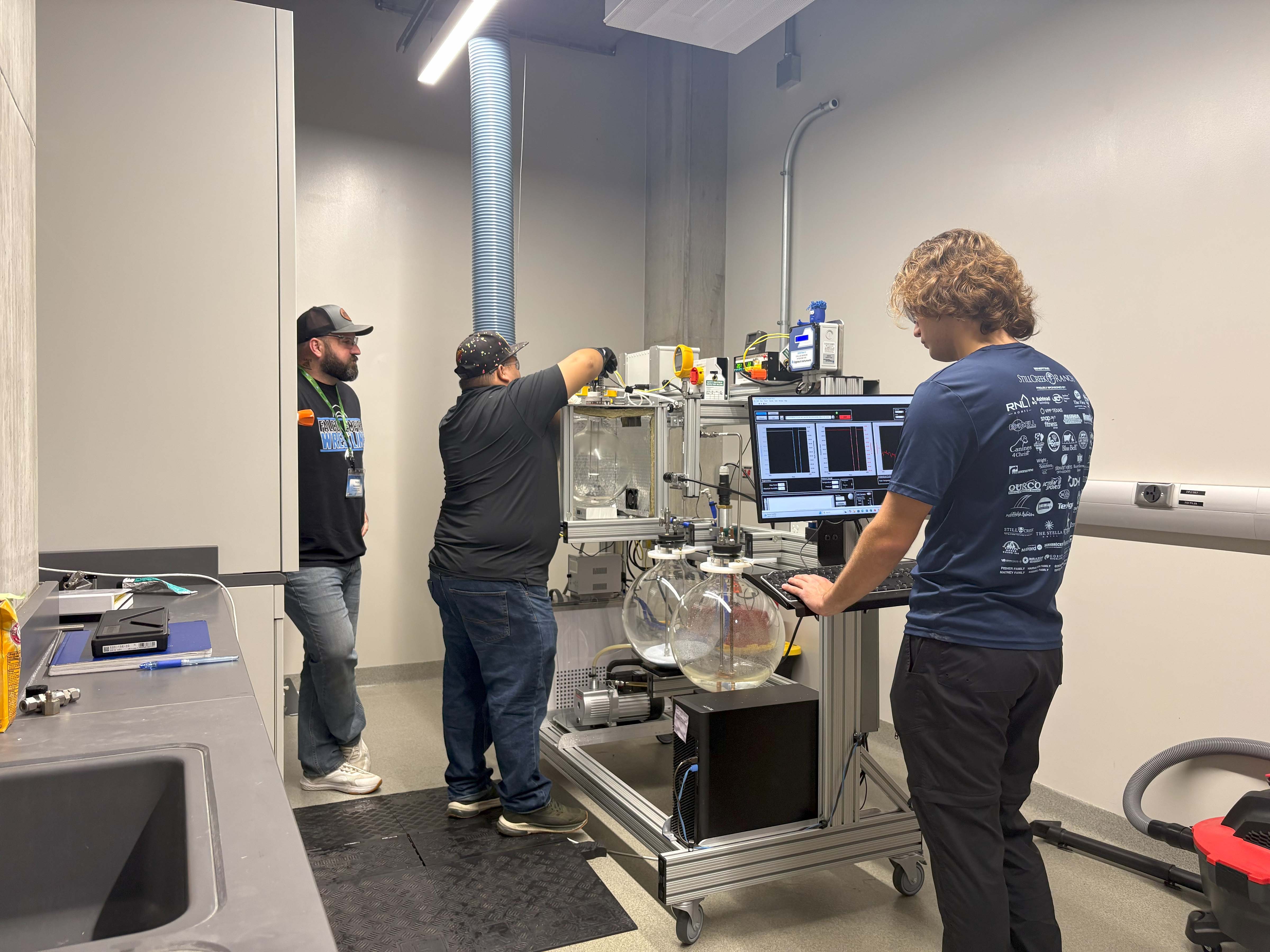 3 people setting up an experiment with monitoring equipment