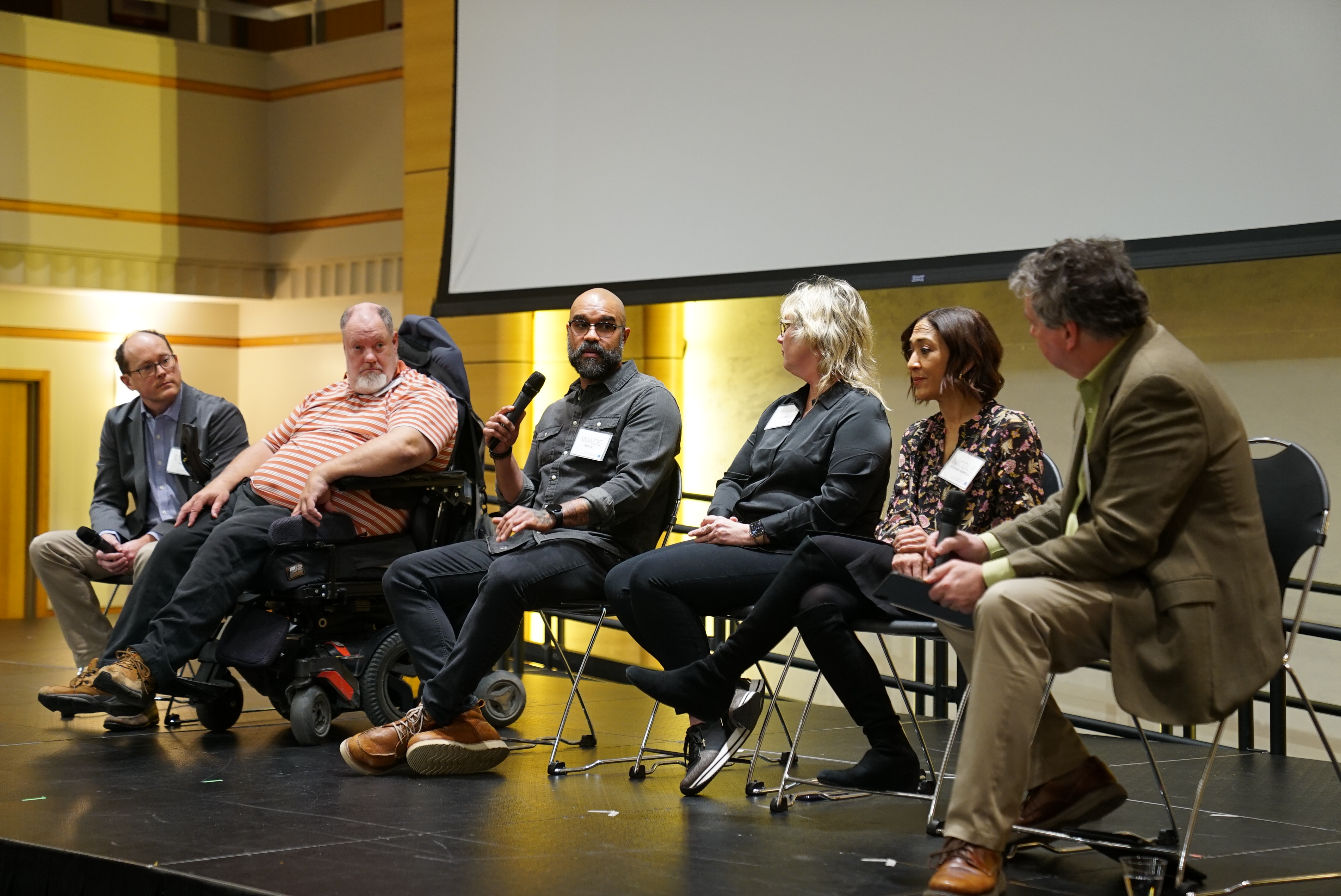 Panelists Evan Dean, Brad Linnenkamp, Wade Kelly, Amy McCart and Nicole Hodges-Persley on stage, with facilitator Simon Atkinson