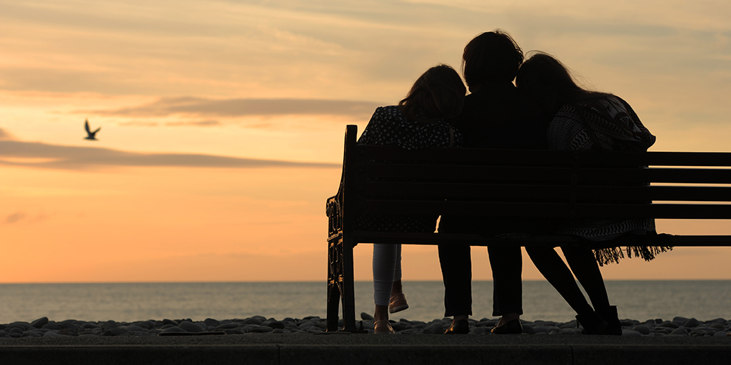 Mother and daughters silhouette on beach. Istock