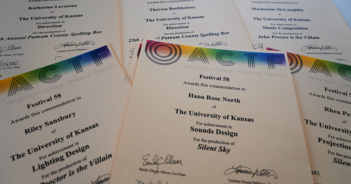 Several paper certificates overlapping each other with KU Theatre festival awards