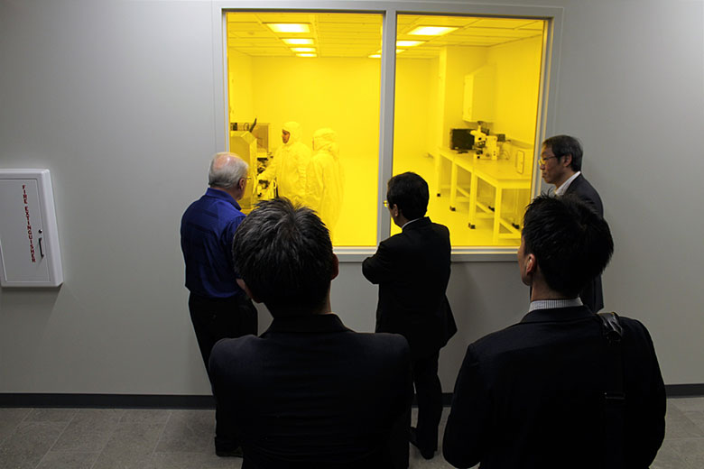 The Shimadzu leaders watch people work in the clean room